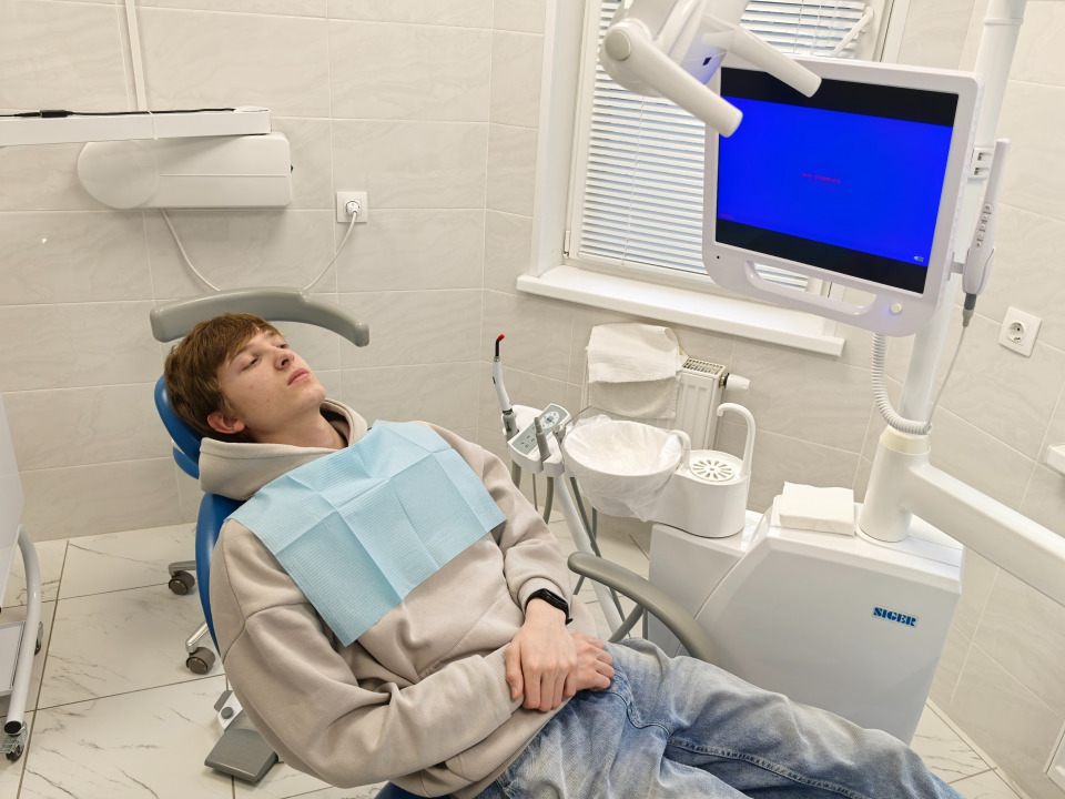 Пациент в кресле в ожидании создания прицельного снимка